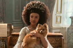 A atriz India Amarteifio segura um cachorro na série Rainha Charlotte, da Netflix