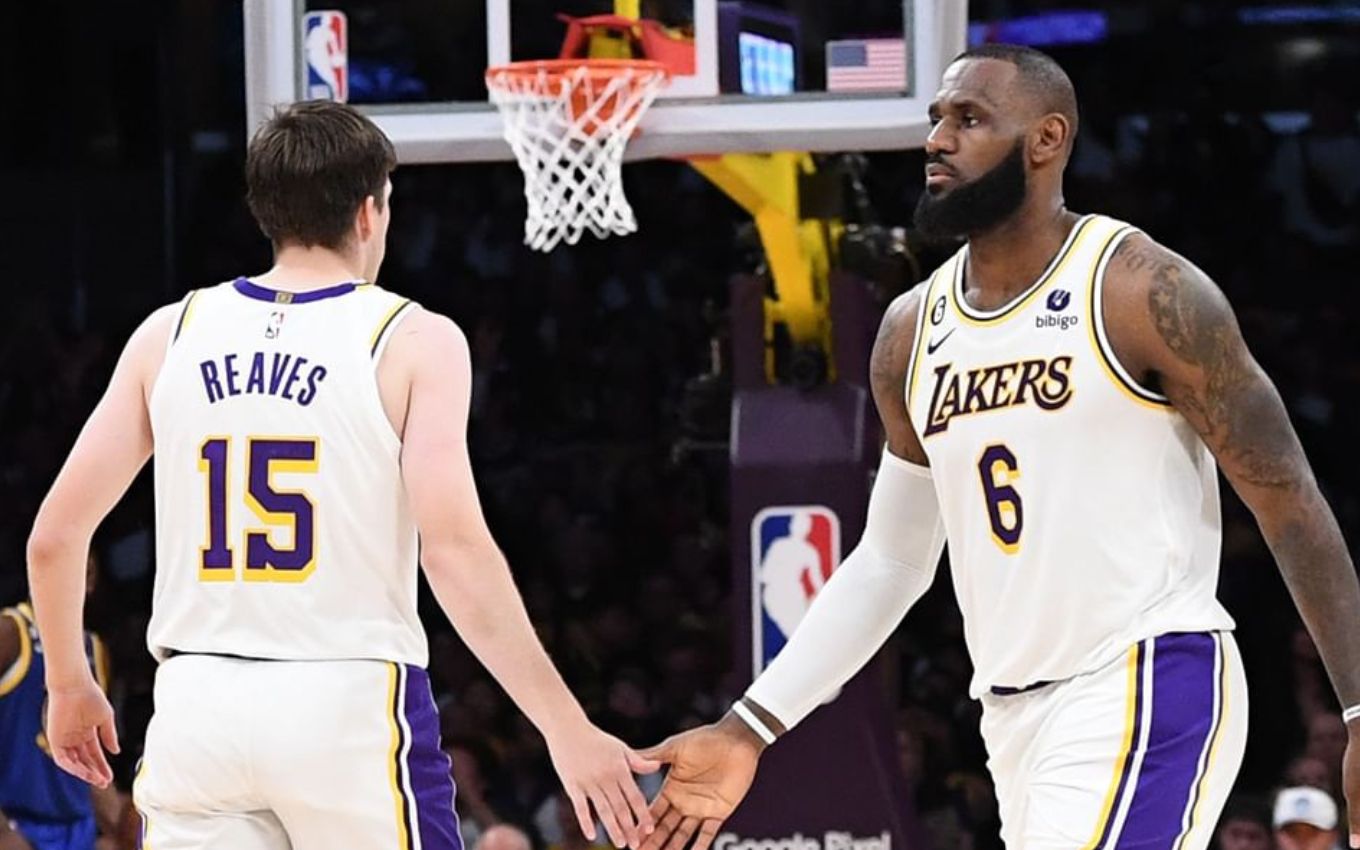 Austin Reaves e LeBron James se cumprimentam em jogo da NBA; eles estão com uniforme branco dos Lakers