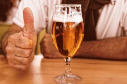 Imagem de homem em balcão de bar com copo de cerveja