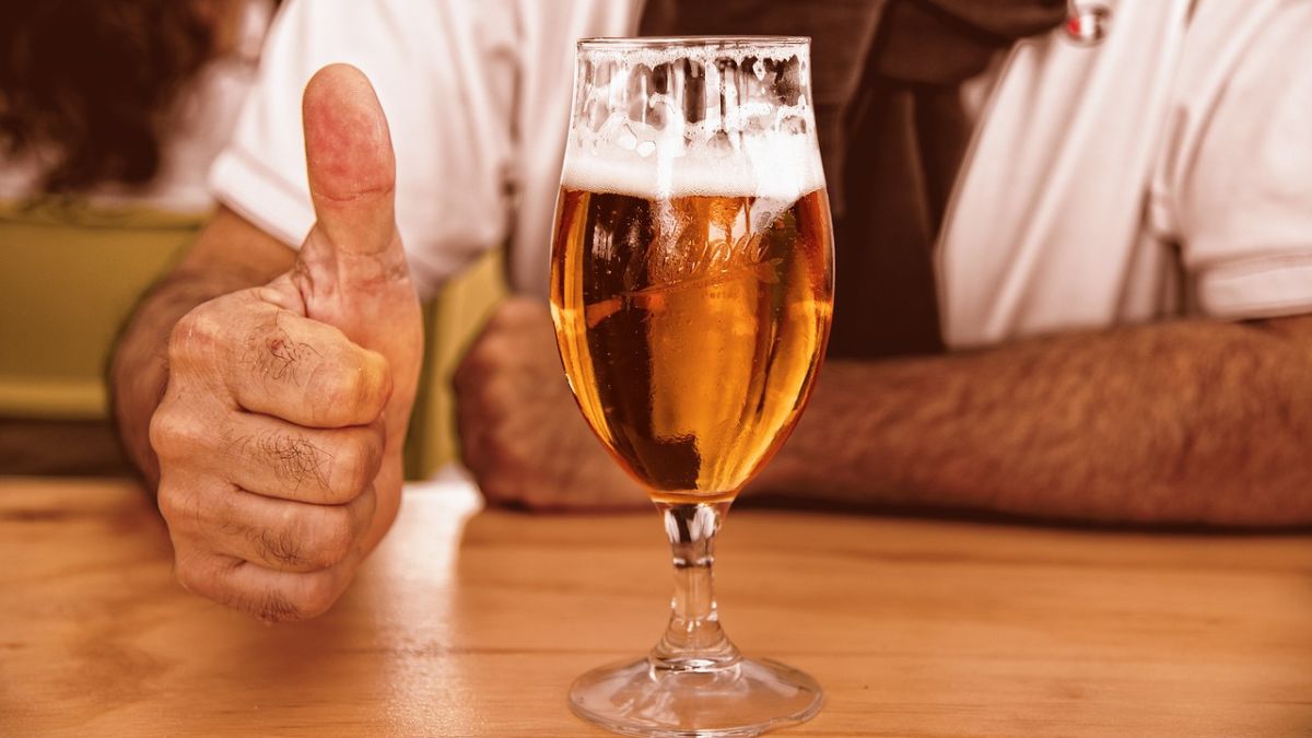 Imagem de homem em balcão de bar com copo de cerveja