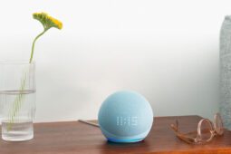 Echo Dot 5 ao centro, sobre um móvel de madeiro: saiba preço do aparelho na Amazon