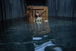 Cena do filme Destinos à Deriva, com a protagonista Mia sentada enquanto o container enche de água